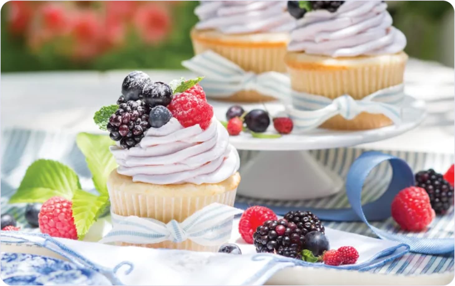 Cupcake decorated with cream, blackberries and mint