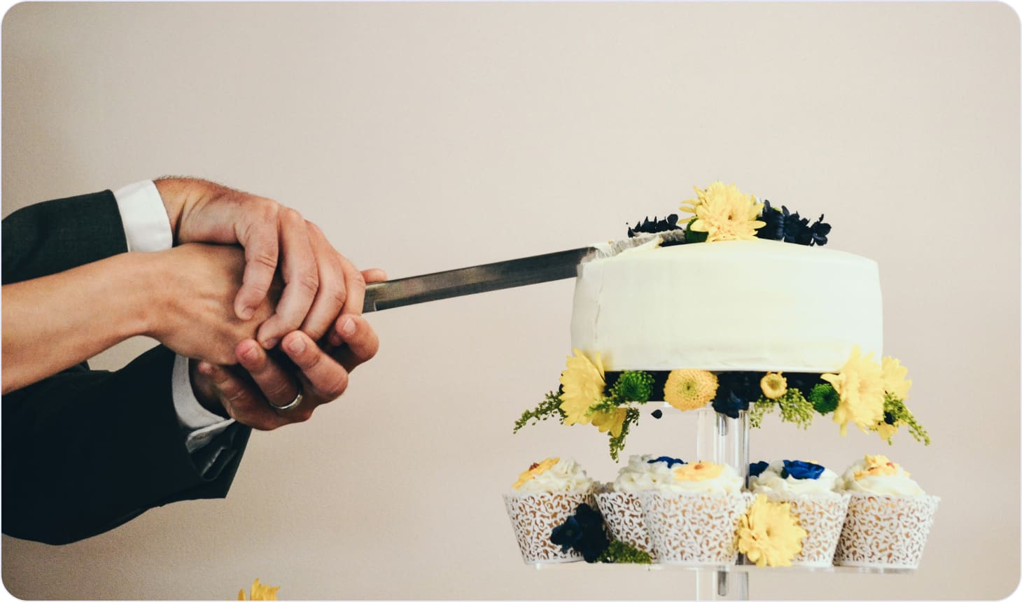 People slicing a wedding cake